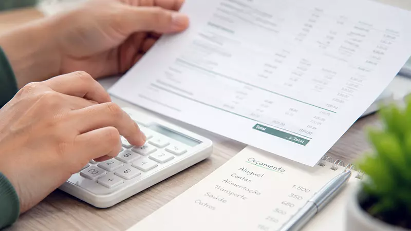 Pessoa organizando contas e documentos financeiros