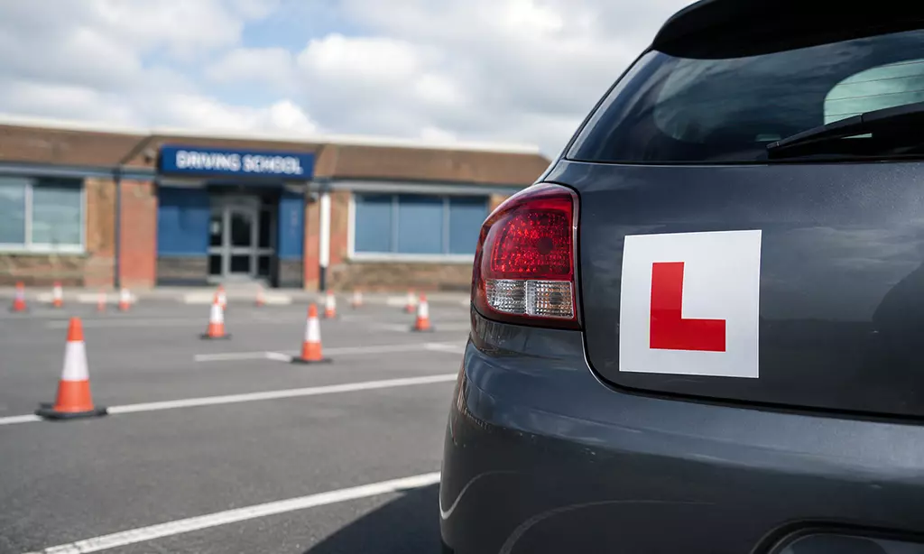 Carro com placa de aprendiz (L) estacionado em frente a uma escola de condução na Irlanda.
