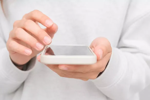 Close-up de uma pessoa utilizando um smartphone para acessar aplicativos indispensáveis para quem vive na Irlanda.