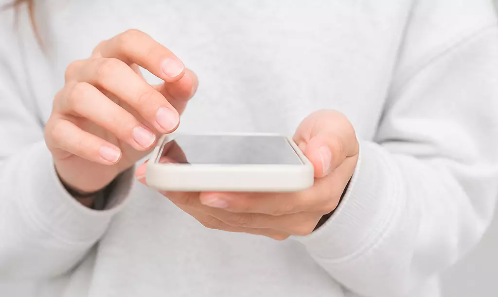 Close-up de uma pessoa utilizando um smartphone para acessar aplicativos indispensáveis para quem vive na Irlanda.