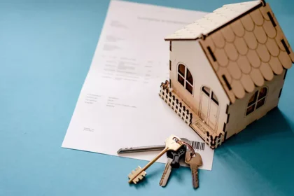 Miniatura de uma casa sobre um contrato de aluguel com chaves, representando o Housing Assistance Payment (HAP) na Irlanda.