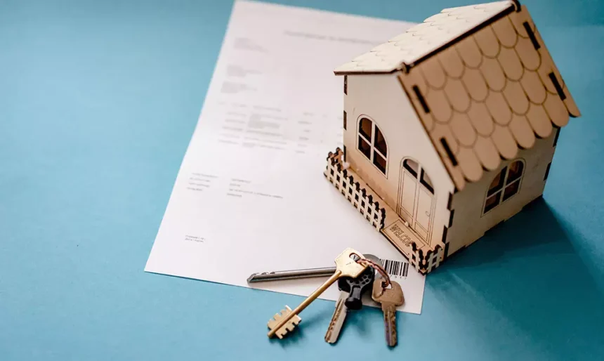 Miniatura de uma casa sobre um contrato de aluguel com chaves, representando o Housing Assistance Payment (HAP) na Irlanda.