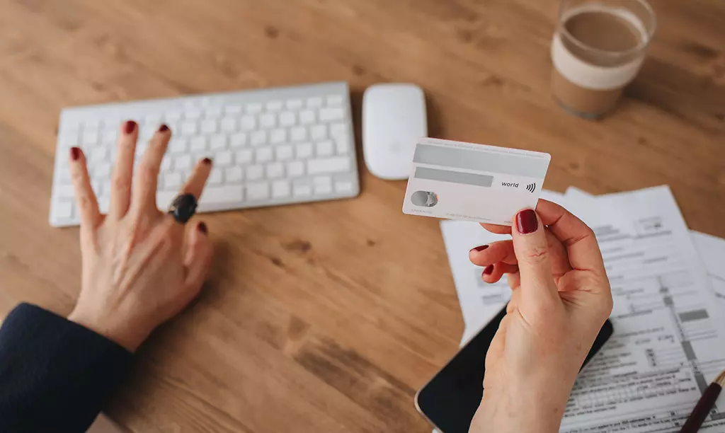 Pessoa utilizando um cartão de crédito para compras online como parte da construção do histórico de crédito na Irlanda.