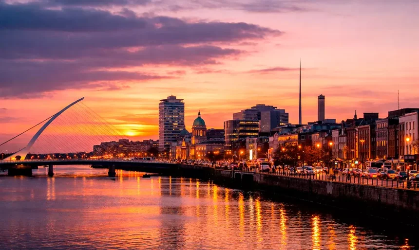 Vista panorâmica do centro de Dublin ao entardecer, com o Rio Liffey e a Samuel Beckett Bridge ao fundo.