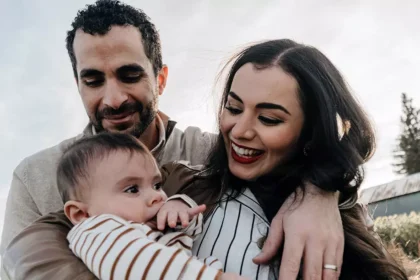 Casal com um bebê em momento de convivência familiar ao ar livre, representando a reunificação familiar na Irlanda.