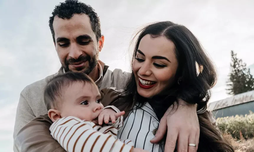 Casal com um bebê em momento de convivência familiar ao ar livre, representando a reunificação familiar na Irlanda.