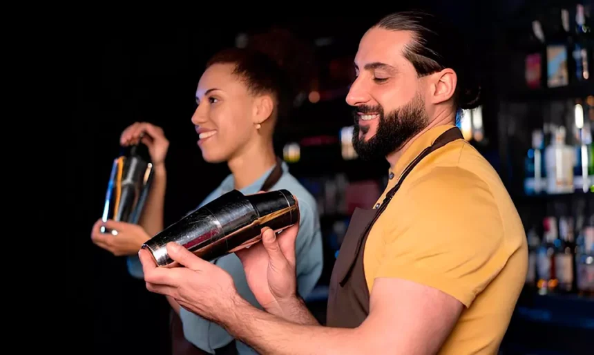 Bartenders trabalhando em um pub na Irlanda preparando bebidas durante o expediente.